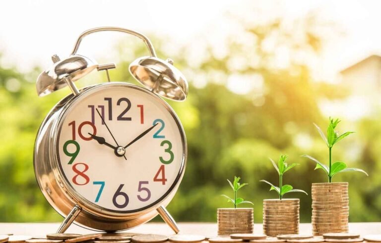 "An alarm clock placed next to stacks of coins with growing plants symbolizing the natural process of wealth accumulation over time. The image reflects how the psychology of saving money works, where patience and consistent efforts lead to growth, just like plants growing with time and attention."