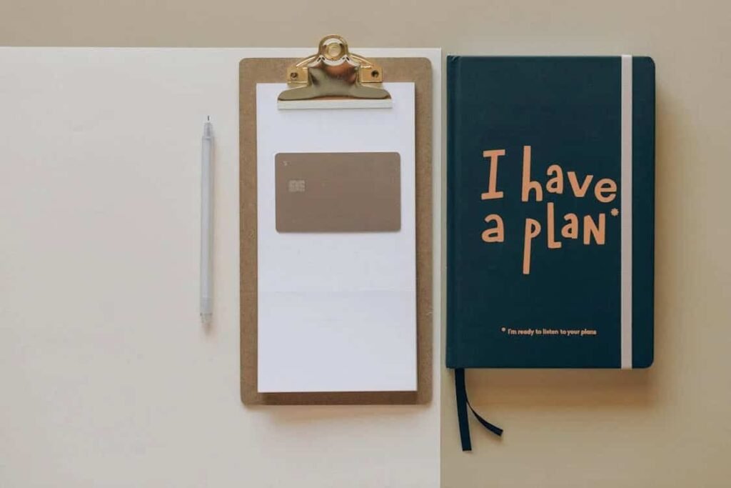 "An image of a clipboard, a pen, and a notebook with the phrase 'I have a plan.' The scene symbolizes the importance of setting clear financial goals, creating a payment plan, and staying organized to avoid debt collection."