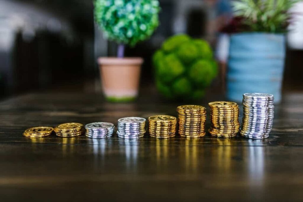 Stacks of gold and silver coins gradually increasing in height, symbolizing the growth of savings over time — a visual reminder of the importance of paying yourself first regularly.