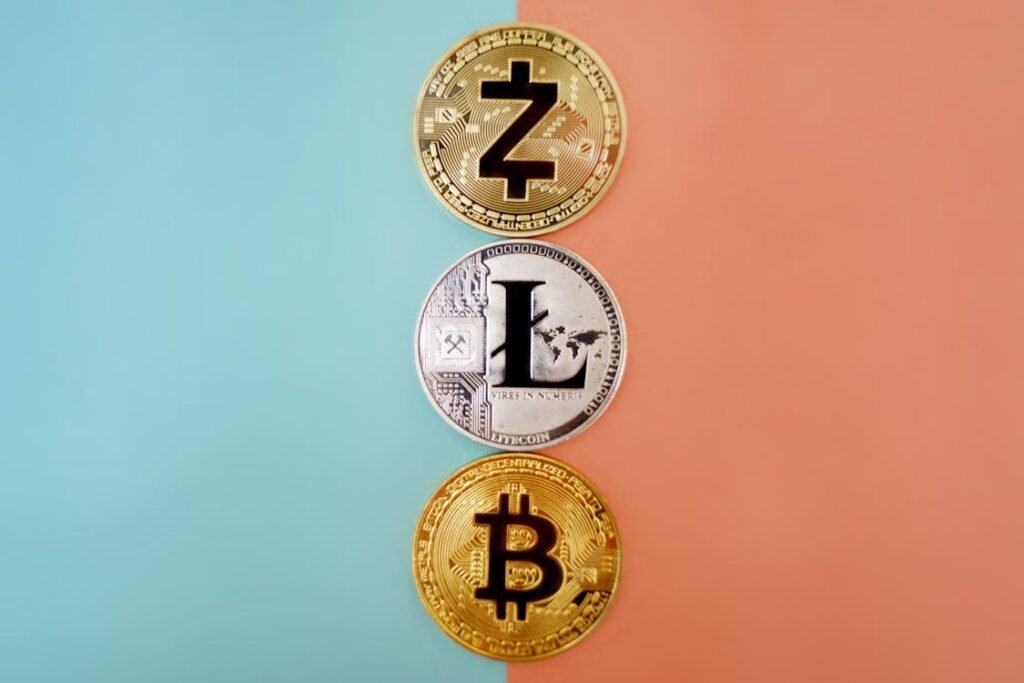 Three cryptocurrency coins (Zcash, Litecoin, and Bitcoin) arranged vertically on a blue and peach background, representing the concept of investing wisely as a teen and exploring modern investment options.