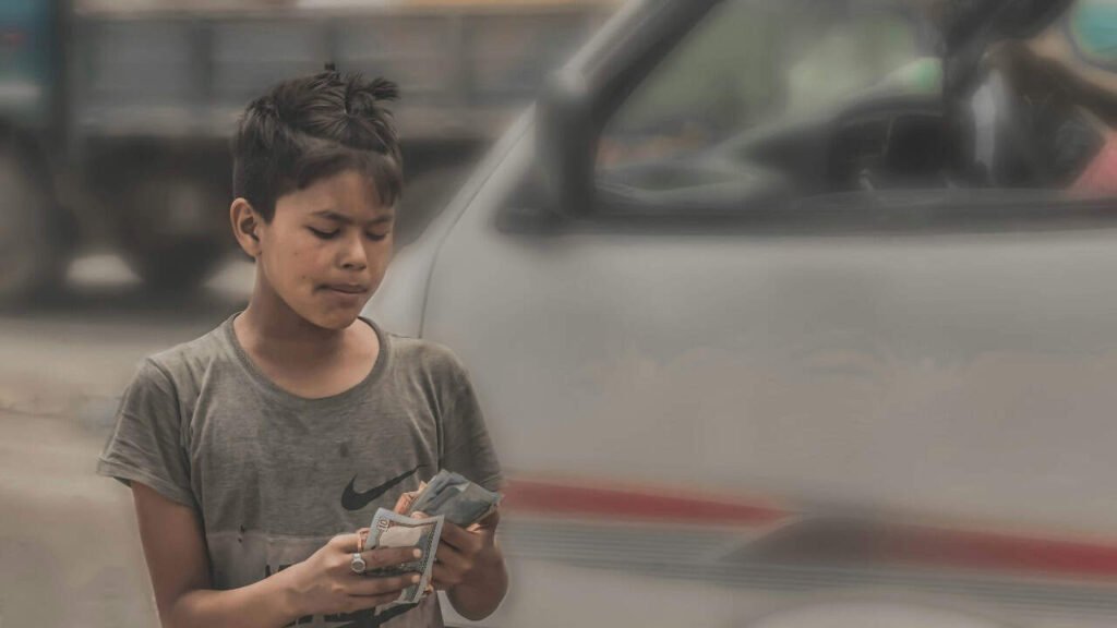 Teen boy counting cash beside a vehicle, showing financial independence and responsibility
