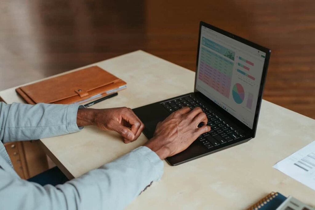 Teen working on a laptop with spreadsheets and charts, representing online jobs for teens managing data and finances from home.