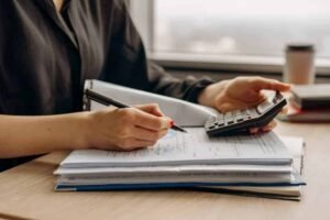 College student using a budgeting template with calculator and notes to manage expenses and savings effectively – practical college student budgeting template for financial planning