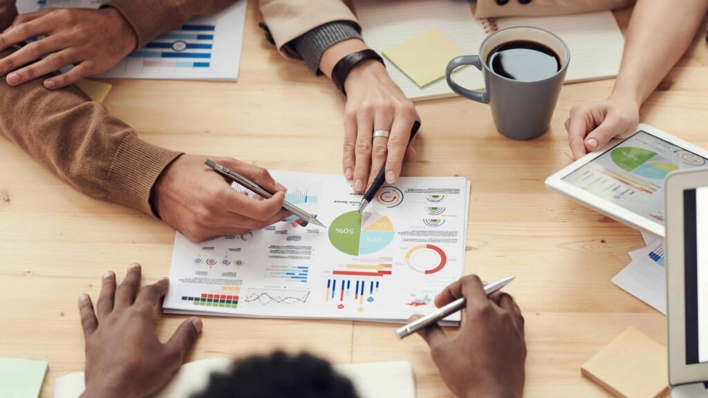 Close-up view of hands reviewing charts and graphs, with a prominent pie chart, illustrating budgeting tips for teens and the importance of understanding financial data.