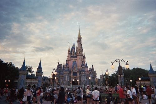 Crowds gathered in front of Cinderella Castle at Disney theme park.
