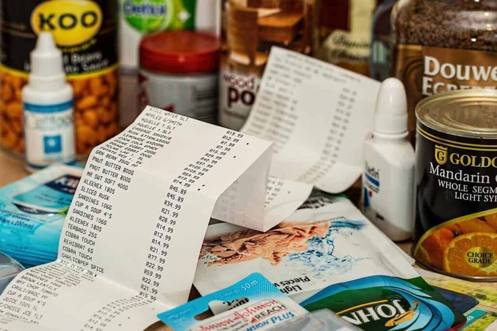 Grocery receipt surrounded by pantry items illustrating monthly food spending and cost tracking