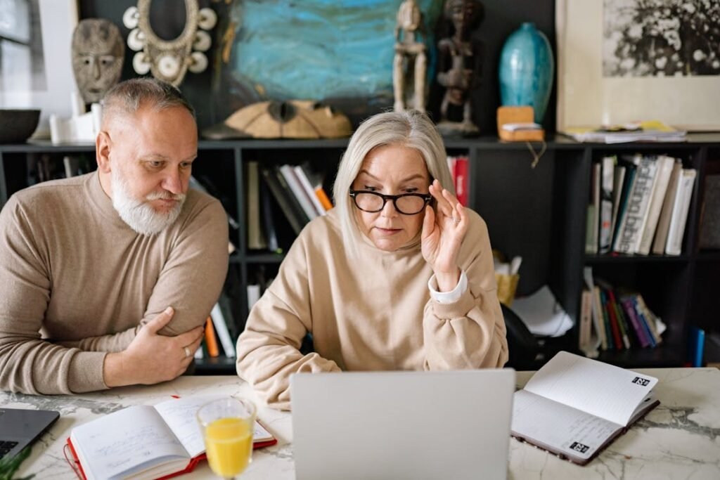 Retired couple reviewing their savings and retirement plans online using a laptop at home.