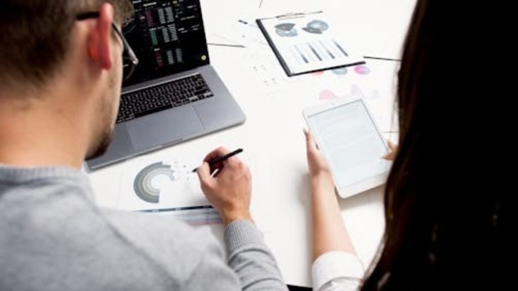 investors analyzing financial data and charts on tablet and laptop