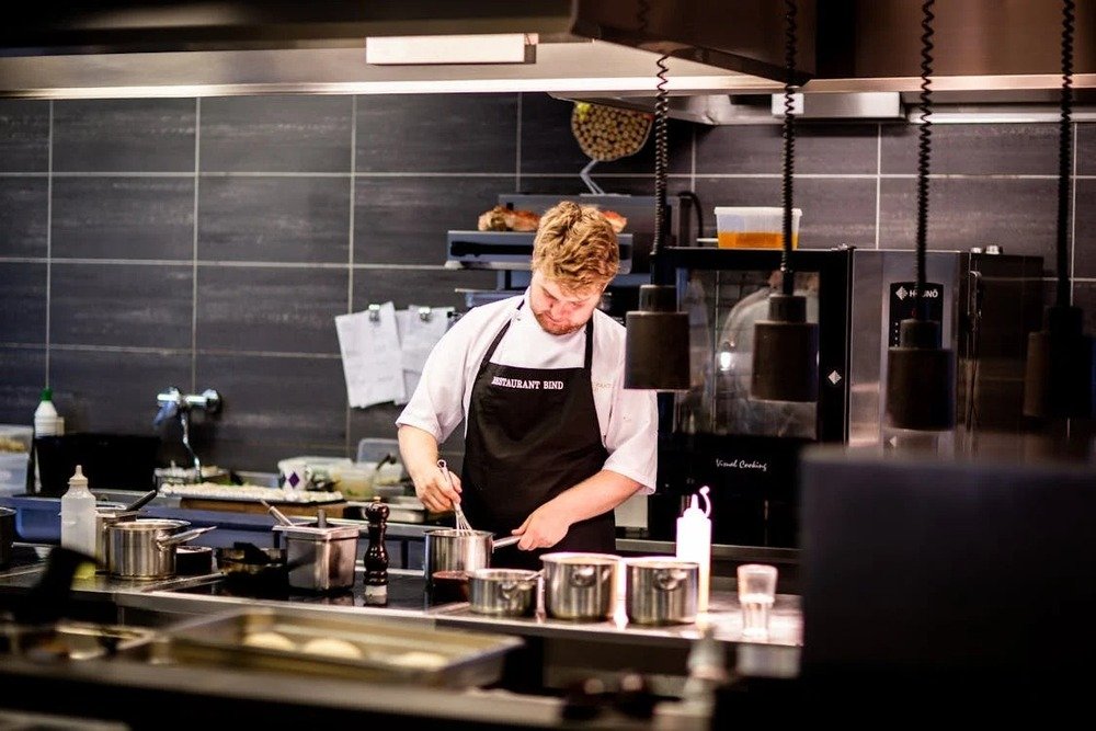 Young student cooking in a modern kitchen as a cost-saving alternative to campus meal plans