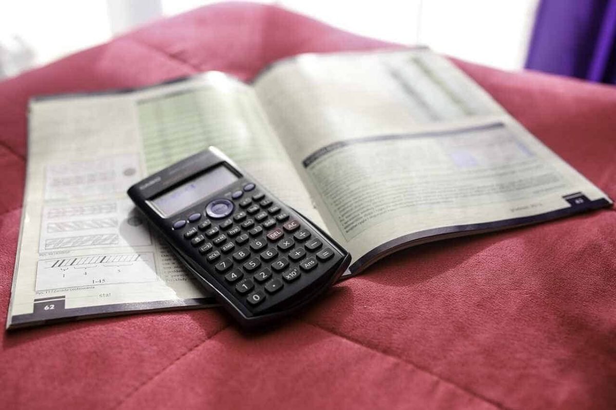 Calculator on financial documents showing the importance of tracking regular expenses to avoid budgeting mistakes."